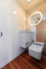 The toilet and open shower are combined into a wet room with teak flooring.