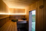 Interior of prefab prefabricated My Galia wood-fired sauna by My Cabin with black alder and spruce fittings millwork.
