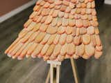 It’s made from pastel-painted wooden petals, a form based on roofing shingles, arranged on an armature. They look like fish scales in an undulating pattern. Scaled-up versions of their work also appeared at Design Miami.