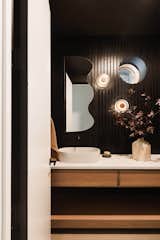 The powder room features two Bruma sconces by Hennepinmade and a Mapocho mirror by Quilicura Design Studio, from The Citizenry.