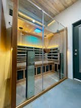 Sauna with wood interior and large glass doors Studio Shed's prefab prefabricated Signature studio model with concrete floors.