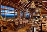 a long bar and big fireplace with antler horn chandeliers in the brush creek ranch lodge