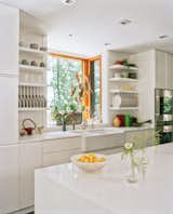 Fruit bowl sits on white table in kitchen with white cabinetry in house in Palisades New York by Charles P Winter renovated by Rick Cook Fox CookFox.