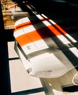 Detail view of the hood and bumper of white Camaro with orange racing stripes in house in Palisades New York by Charles P Winter renovated by Rick Cook Fox CookFox.