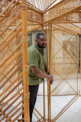 Portrait of Nifemi Marcus-Bello standing inside whicker sculpture pavilion.