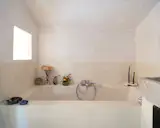 The primary bathroom is decorated with found stones, a handmade porcelain candleholder, and other small objets d’art.