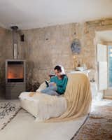 Outside, Eva planted wildflowers, grapevines, and other flora along the perimeter of the home. Inside, a sitting area by a Skantherm fireplace is a nice spot to cozy up with a book.
