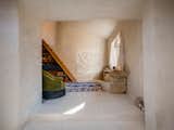 Below the window is a bench Eva made using an old wooden plank and loose stones found during the building’s renovations. The curtains were handsewn from pieces of lace she bought at a flea market in nearby Arles.