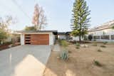 The fenced-in, single-story home sits back off the street, behind desert landscaping .