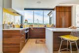 Prefab prefabricated home house by Method Homes on the San Juan Islands in Washington with kitchen with medium-toned wood cabinetry, white counters, and yellow ceramic backsplashes.