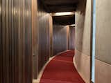 a hallway with a red carpet and wood walls in a murder at the end of the world