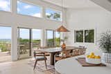 Large windows and sliding glass doors frame striking ocean views in the dining area.