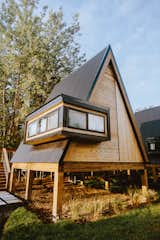 The one-bedroom A-frames are connected by a 350-foot walkway along the backside of the cabins. Each unit has access to a private hot tub.  Photo 3 of 4 in Meet the A-Frame-Obsessed Couple on a Mission to Build 20 “Tree House Airbnb Hotels”