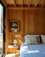 The bedroom on the first floor gets natural light from a floor-to-ceiling window.  Photo 15 of 18 in Budget Breakdown: An Austin Architect Spins Michael Pollan’s Food Advice Into a Healthy Home