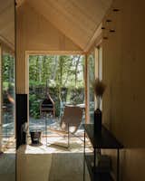 While prefabs cabins have the same amenities and footprint, orienting the long side of Kabn 2 towards the loch shortened the inbuilt bench. Its fabric woven from PET yarn, a lounge chair by Ferm Living was added by the window to compensate.
