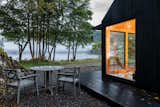 Kabn prefab prefabricated off-grid, boutique retreat cabin holiday stay tiny home on the shores of Loch Fyne, Scotland, with gabled roof, blackened shou sugi ban cladding, and wraparound deck.
