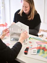 Sisters Anda and Jenny French of Boston-based architecture firm French 2D work on architectural model of a three-story house.