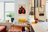 Yellow bar cart sits in front of wood kitchen island in Queens, New York, apartment whose kitchen was renovated by architects Lane Rick and Can Vu Bui.