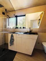 As with the rest of the interiors, the bathroom is clad in maple plywood. Its severe angles echo the steel fins of the home’s entry.