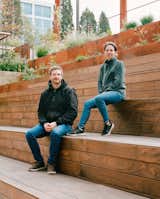 Joshua P. LaFreniere and Jennifer LaFreniere of JPL-A, Block Architects, sit on the tiered wood seating benches outside PorchLight Eastgate shelter. 