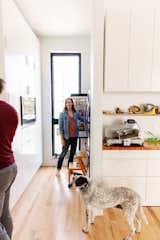 Emilie Taylor and Seth Welty of design firm Colectivo design their own house in the Black Pearl neighborhood of New Orleans, Louisiana LA, with kitchen with light wood floors, white cabinetry, and wood counters.