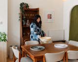 Ninze Chen places white stone ceramic bowl onto medium-toned wood table in her vintage furniture store Long Weekend in Livingston Manor, Catskills, New York NY.