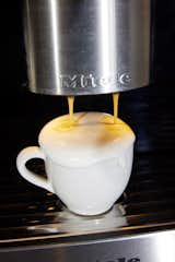 Close up of Miele CVA 7370 Built-in Coffee Machine pouring foam into mug cup.