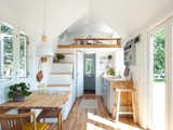 Interior of Norske Mikrohus tiny house micro house heim adu accessory dwelling unit prefab prefabricated in Norway with white walls, lofted bedroom, and oak floors.