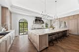 Mimi Collins converted the home’s former salon into a kitchen with modern amenities and access to the outdoors through arched doorways that match those of the existing sunroom.  Photo 5 of 5 in In This Town, Renovating Instead of Tearing Down Puts Money Back in Your Pocket