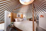 Upstairs, a lofted bedroom with a half bath is set beneath a circular skylight.&nbsp;