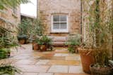 A spacious courtyard, lined with flagstones, presents a private outdoor oasis.