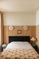 The walls of the guest bedroom are paneled with locally sourced wood.