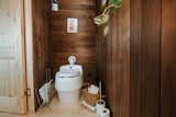 Bathroom of Vagabond Haven's prefab tiny called Nature Pod with pine floors and walls and incinerating toilet.