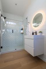 The shower booth has a fiberglass pan, subway tile walls, and two corner shelves. The bathrooms also come equipped with a 28-gallon electric water heater from Rheem.