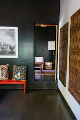 Inside the former caretaker’s cottage, eclectic furnishings and art belong to Naeem and Bethan’s current tenants, Verena Phipps and Steve Coomans.