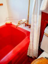 In the bathroom, a bright red acrylic soaking tub—“found through sheer luck at a Japanese hardware store,” says Ryan—matches the boat’s colorful outer doors. Brass fixtures from Waterworks pick up on the brass trim elsewhere.