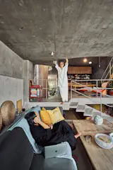 The second story holds a family area furnished with an Eames lounge chair and a live-edge suar wood table that Emylia uses to work on art projects.