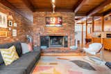 The main living room is anchored by original beamed ceilings and a wide brick fireplace.