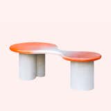 Peanut Coffee Table Lavastone by Uchronia with orange and white top and concrete legs.