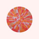 Round Rug by SHORE with pattern of radiating orange, red, pink, light blue, and brown blocks.