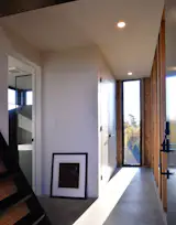 The interiors combine polished concrete floors, white walls, and exposed framing.