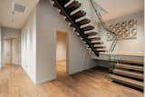 A wood-and-glass staircase connects the common areas&nbsp; with the spacious bedrooms.