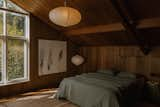 A vaulted wood ceiling caps the primary bedroom suite on the upper floor.