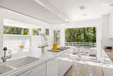 A glass block wall with a clerestory and a floor-to-ceiling picture window bring ample sunlight into the kitchen.