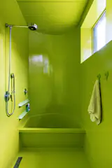 A lime-green bathroom on the lower level has fixtures from Brazilian manufacturer Docol.