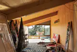 On the upper level, Luiza’s lofted art studio spans the length of the house below the tall end of the roof’s pitch.