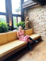 Writer Lina Abascal sits on built-in seating in the living room of Frank Lloyd Wright’s longtime home, studio, and architecture school in Spring Green, Wisconsin.