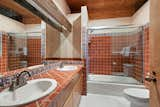 Rustic vibes continue in the primary bath, which features custom tile and a dual vanity.