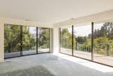 Sliding glass doors open the primary bedroom to the wraparound balcony.