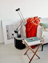 At one end of an Ikea couch are a cut wool blanket by Nanimarquina for Emiliana Design Studio and a Tizio lamp from Artemide.